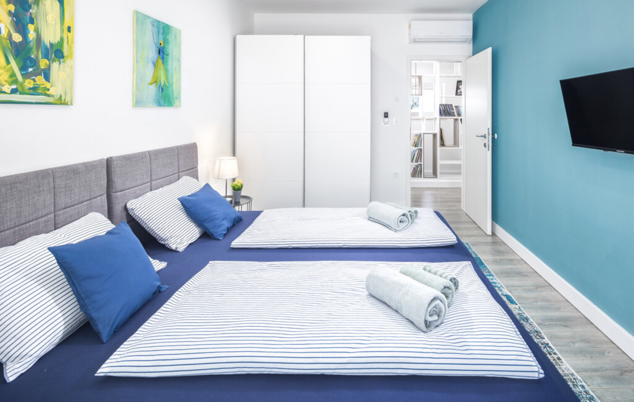 Villa Mia blue bedroom with double bed, wardrobe and wall-mounted TV